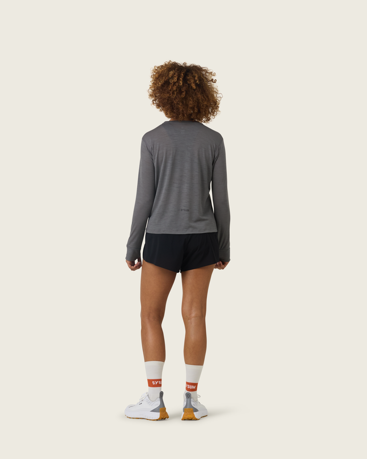 Women’s merino long-sleeve running top in Slate from Sysum, lightweight knit texture visible, photographed in a neutral studio setting.