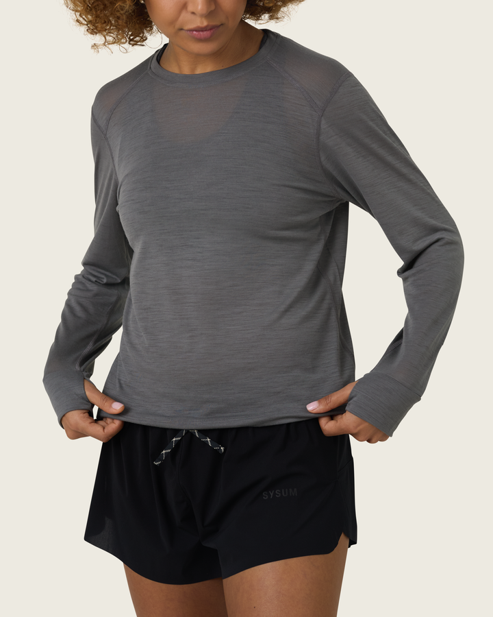 Women’s merino long-sleeve running top in Slate from Sysum, lightweight knit texture visible, photographed in a neutral studio setting.