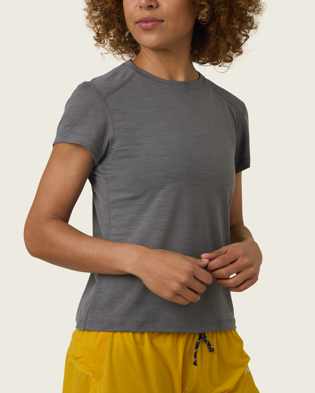 Women’s merino short-sleeve running tee in Slate from Sysum, lightweight knit texture visible, photographed in a neutral studio setting.