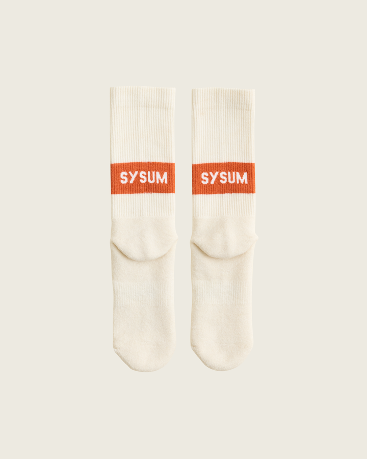Woollen crew running socks in Clay from Sysum, mid-length design with cushioned zones and textured knit visible, photographed in a neutral studio setting.