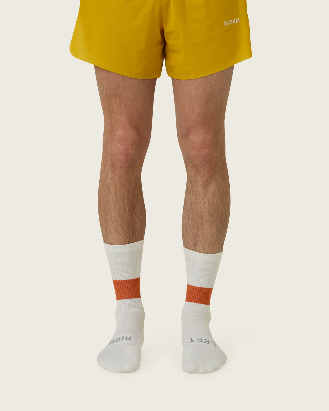 Woollen crew running socks in Clay from Sysum, mid-length design with cushioned zones and textured knit visible, photographed in a neutral studio setting.