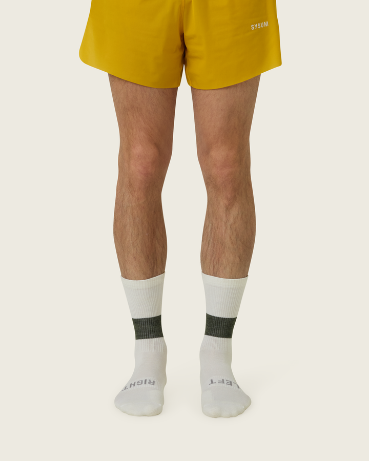 Woollen crew running socks in Moss from Sysum, mid-length design with cushioned zones and textured knit visible, photographed in a neutral studio setting.