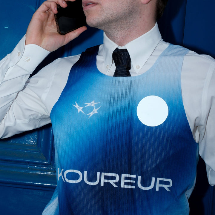 Limited Edition Participation Koureur Running Singlet in blue with white accents displayed on a hanger.