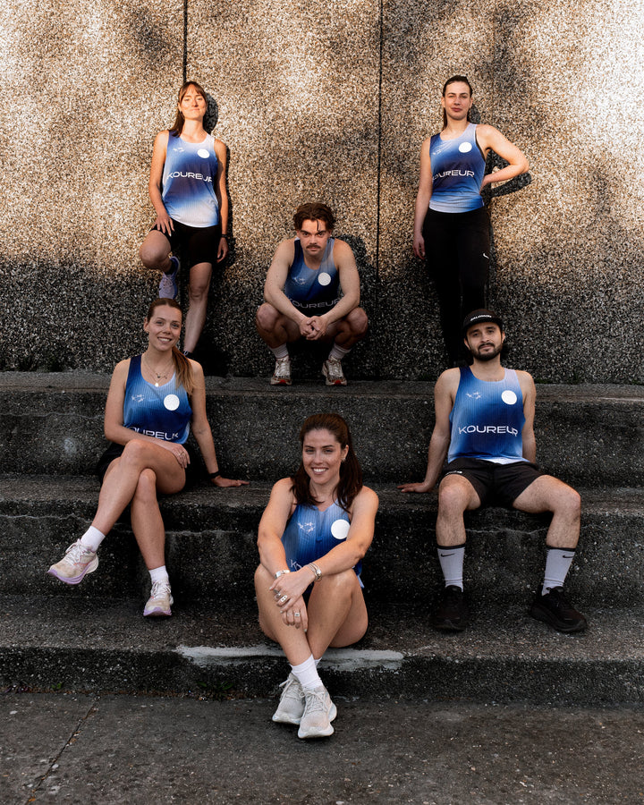 Limited Edition Participation Koureur Running Singlet in blue with white accents displayed on a hanger.