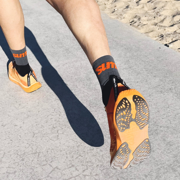 4T2 one more running shoe in orange, featuring a breathable upper and a durable rubber outsole designed for speed and traction.