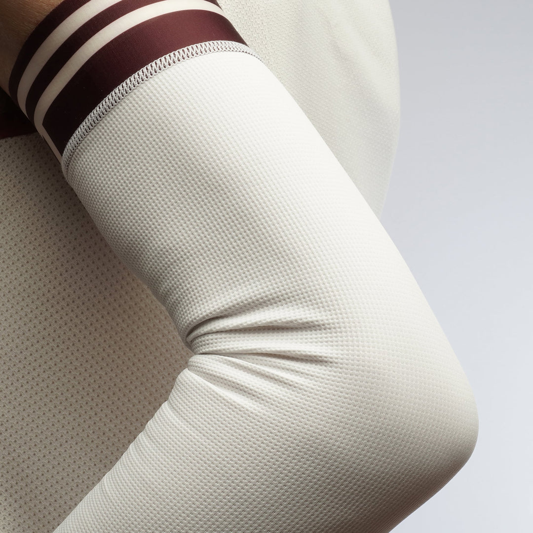 White racing arm sleeve with lightweight compression and asymmetrical design for running and racing.