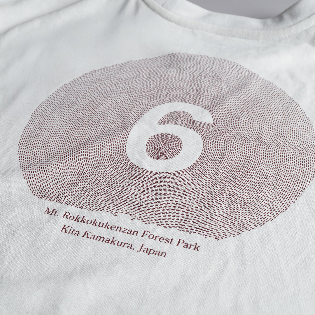 T2 - Trail Tee in white, featuring a relaxed fit and crafted from high-performance Swiftex 2 fabric, displayed on a neutral background.