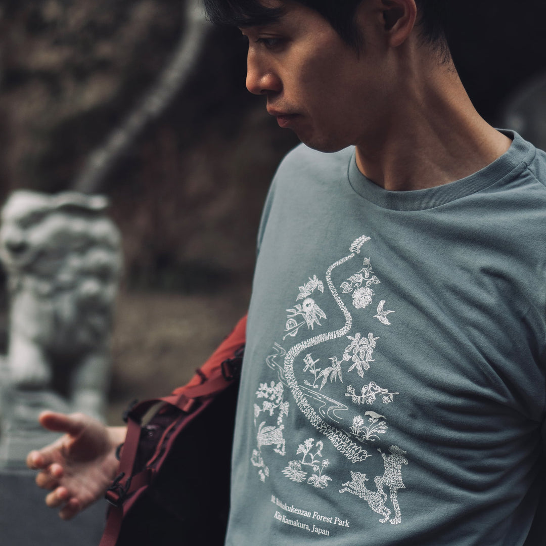 T2 - Trail Tee by Mariko Yamamoto in blue-gray, a relaxed-fit T-shirt made of high-performance fabric, suitable for outdoor activities.