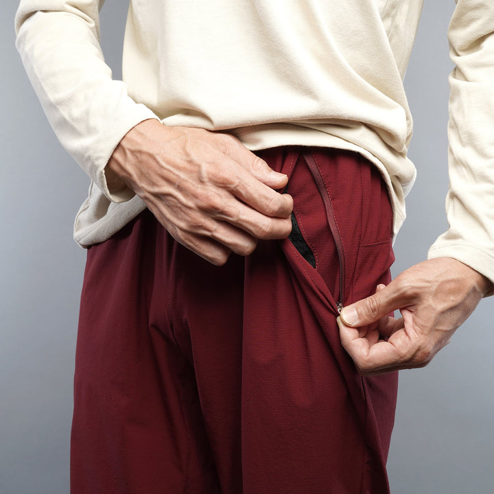 T2 Traverse Pants 2025 fastpacking pants in burgundy with reinforced crotch and integrated inner shorts